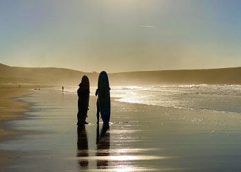 A couple of surfers on a North Devon beach